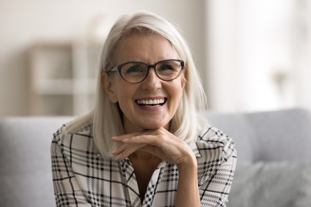 Laughing woman with silver hair and glasses, reflecting the confidence of tooth-colored inlays and onlays in La Mesa, CA