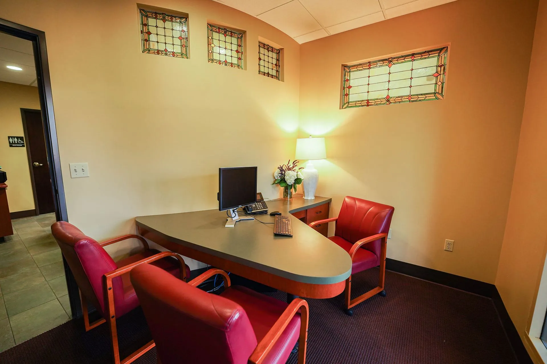 Private consultation room with red leather chairs and stained glass windows where La Mesa dental patients review treatment plans