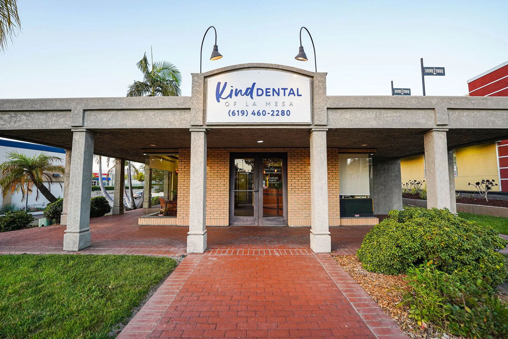 Front entrance, signage, and brick walkway of Kind Dental of La Mesa, a welcoming dental office on Jackson Drive in La Mesa, CA